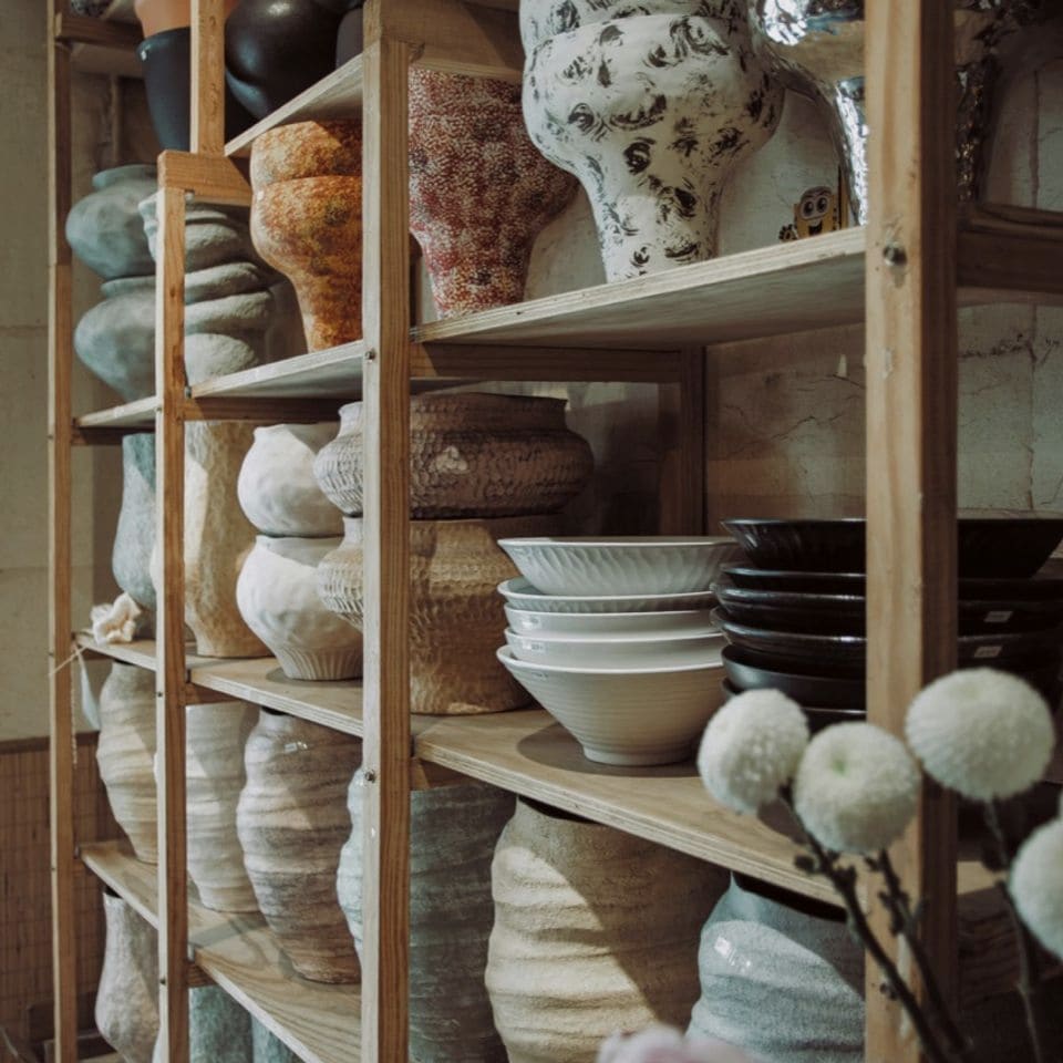 Shelves holding a growing collection of finished ceramic work.